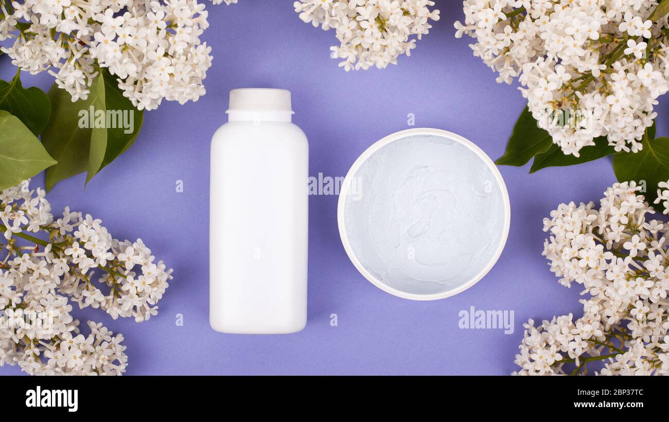 beauté, neige-blanc soins de la peau cosmétiques sur un fond violet avec des fleurs blanches de lilas. Banque D'Images
