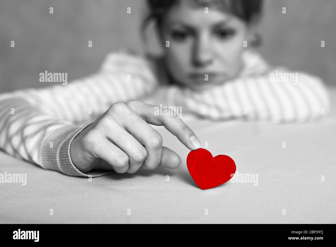 Bouleversee Et Triste Fille Touche Cœur Rouge Avec Le Doigt Tout En Pensant A L Amour Ou La Rupture Sans Requised Tout Est Noir Et Blanc Sauf Le Cœur Focus Et A Photo