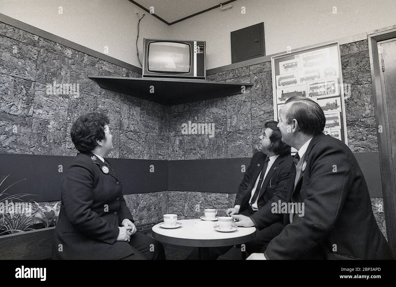 Intérieur, personnel de bus salle de repos New Cross, sud de Londres, Angleterre, 1974, la photo montre trois membres d'équipage en uniforme ayant une pause et une tasse de thé et regardant une petite télévision portable. Banque D'Images