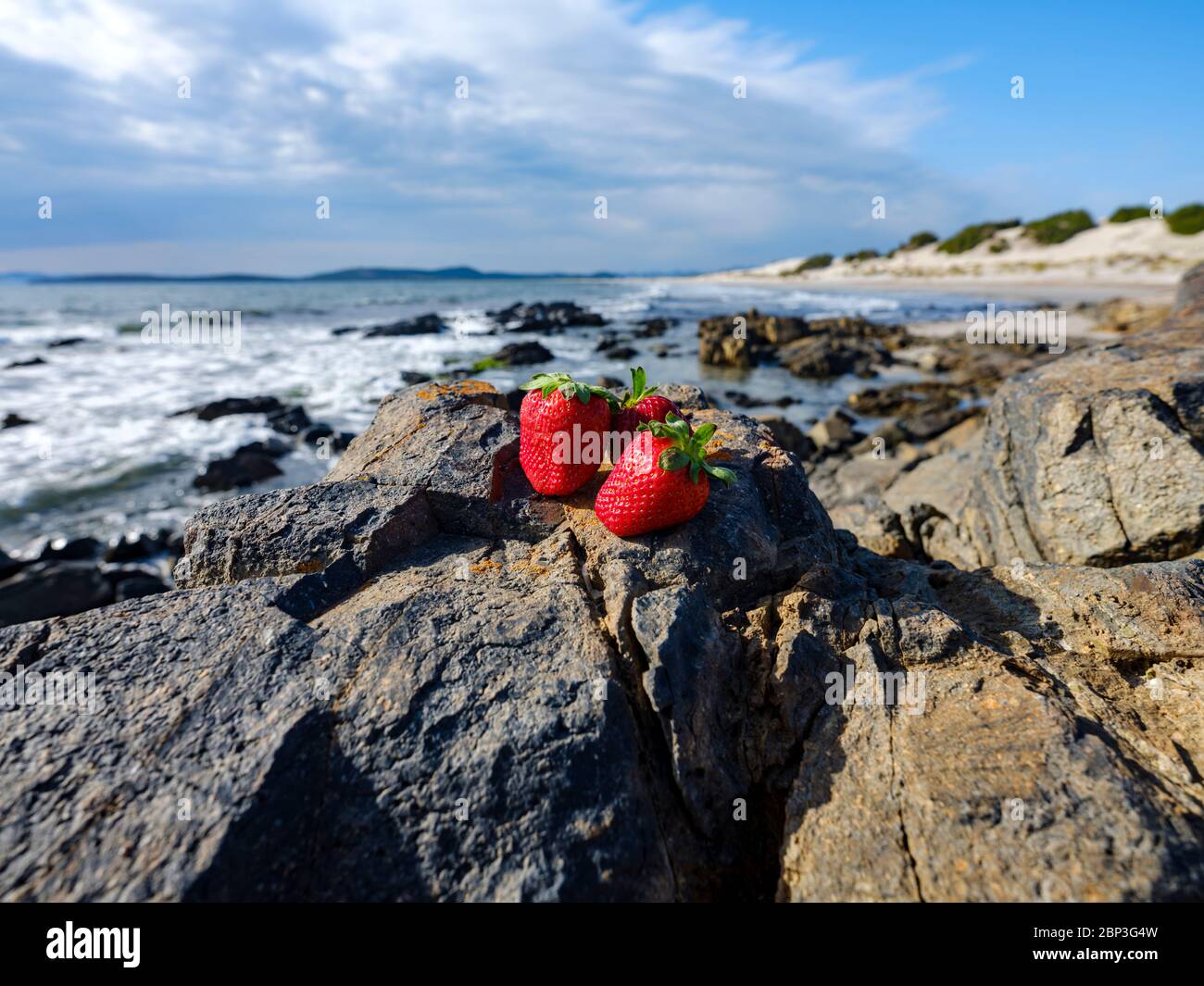 Fraises rouges avec fond de vagues, Porto Pino, Sant'Anna Arresi, Sardaigne, Italie Banque D'Images