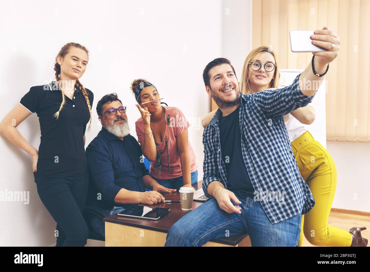 Heureux collègues multiraciaux prenant le selfie au bureau Banque D'Images