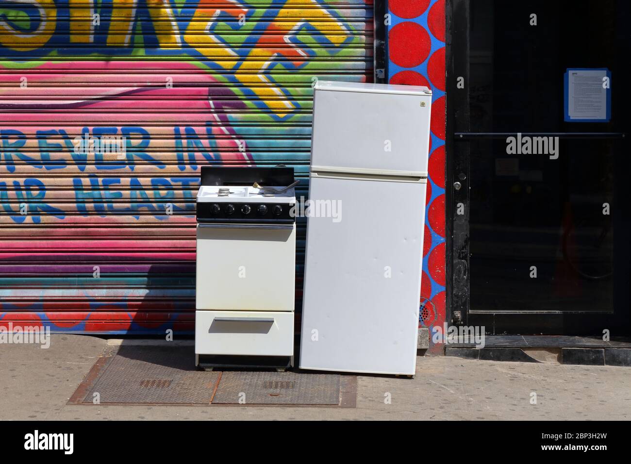 Un poêle à gaz et un réfrigérateur à l'extérieur d'un immeuble de New York avec un fond coloré Banque D'Images