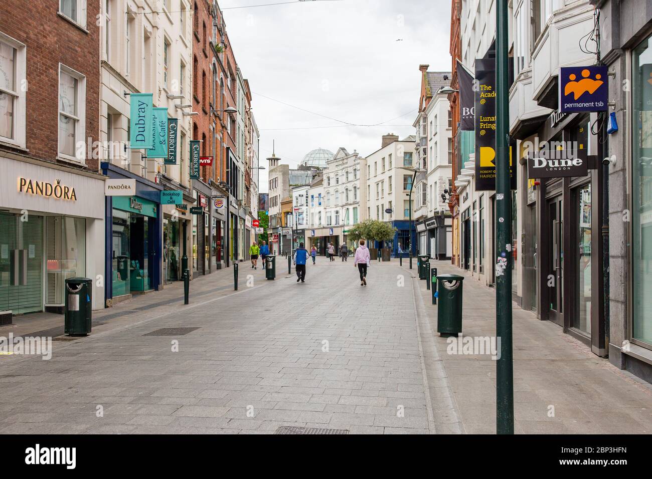 Des piétons se balader dans une rue Grafton déserte du centre-ville de Dublin alors que les magasins restent fermés en raison de restrictions liées à une pandémie de coronavirus. Banque D'Images