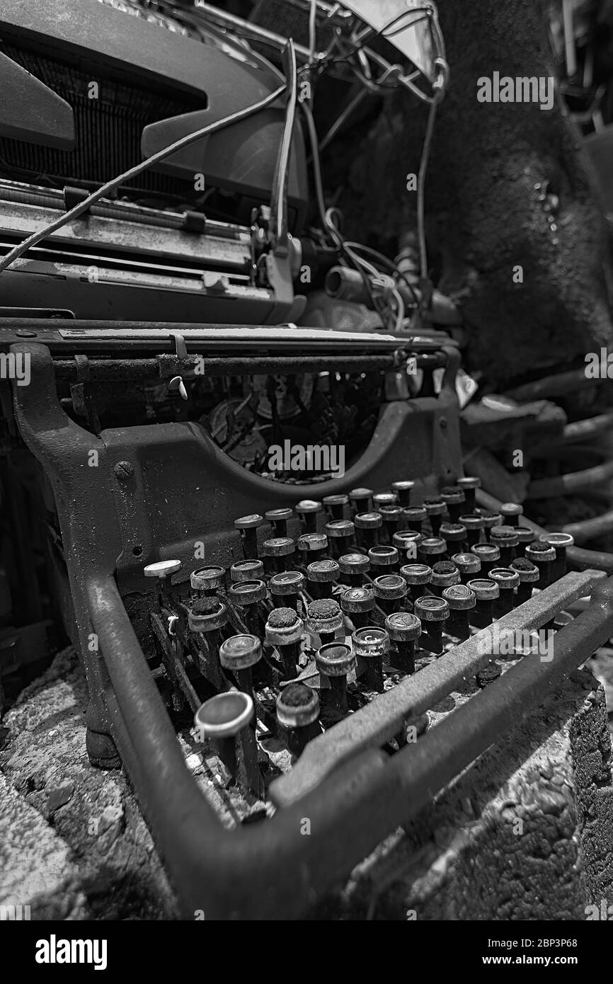 Machine à écrire manuelle vintage cassée sur le sol en noir et blanc. Conceptualiser les auteurs bloc ou une occupation passée n'est plus en usage. Banque D'Images