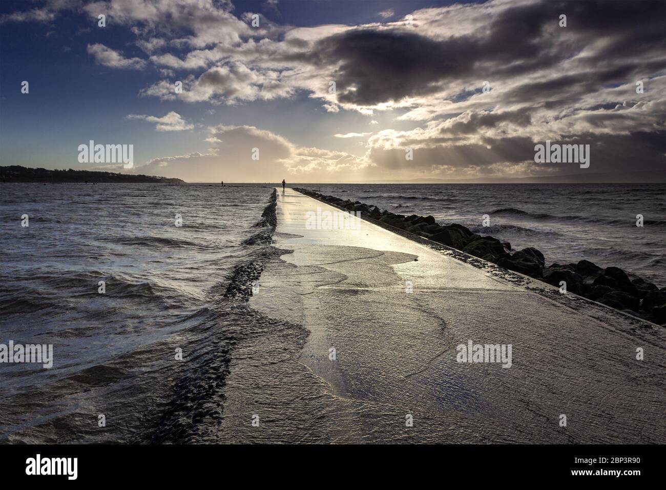 L'eau se déllait sur la passerelle autour du lac Marine, West Kirby. Marée haute et vent. Banque D'Images