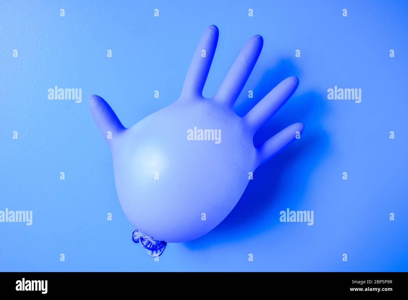 Gant médical en latex bleu sur fond bleu pastel. Épidémie minimale de coronavirus. Concept panique, espace de copie, sécurité, quarantaine Banque D'Images