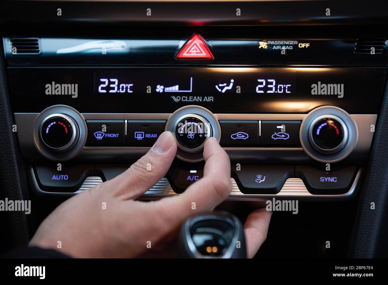 Tournez manuellement le bouton de climatisation dans une voiture de luxe moderne coréenne. Banque D'Images