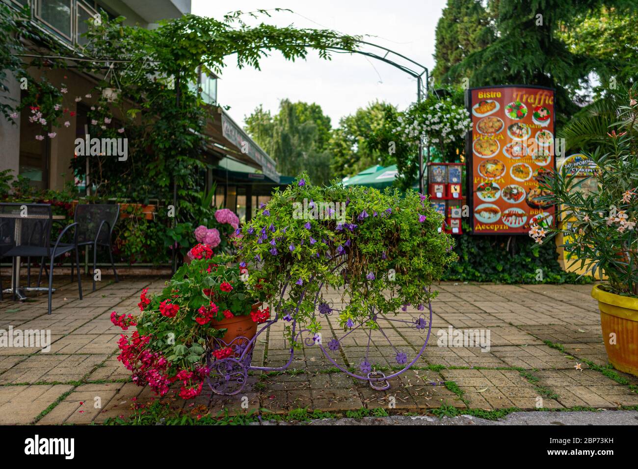 POMORIE, BULGARIE - 25 juin 2019 : Décoration sous la forme d'un vélo dans les fleurs en face de l'entrée du café de la ville. Banque D'Images