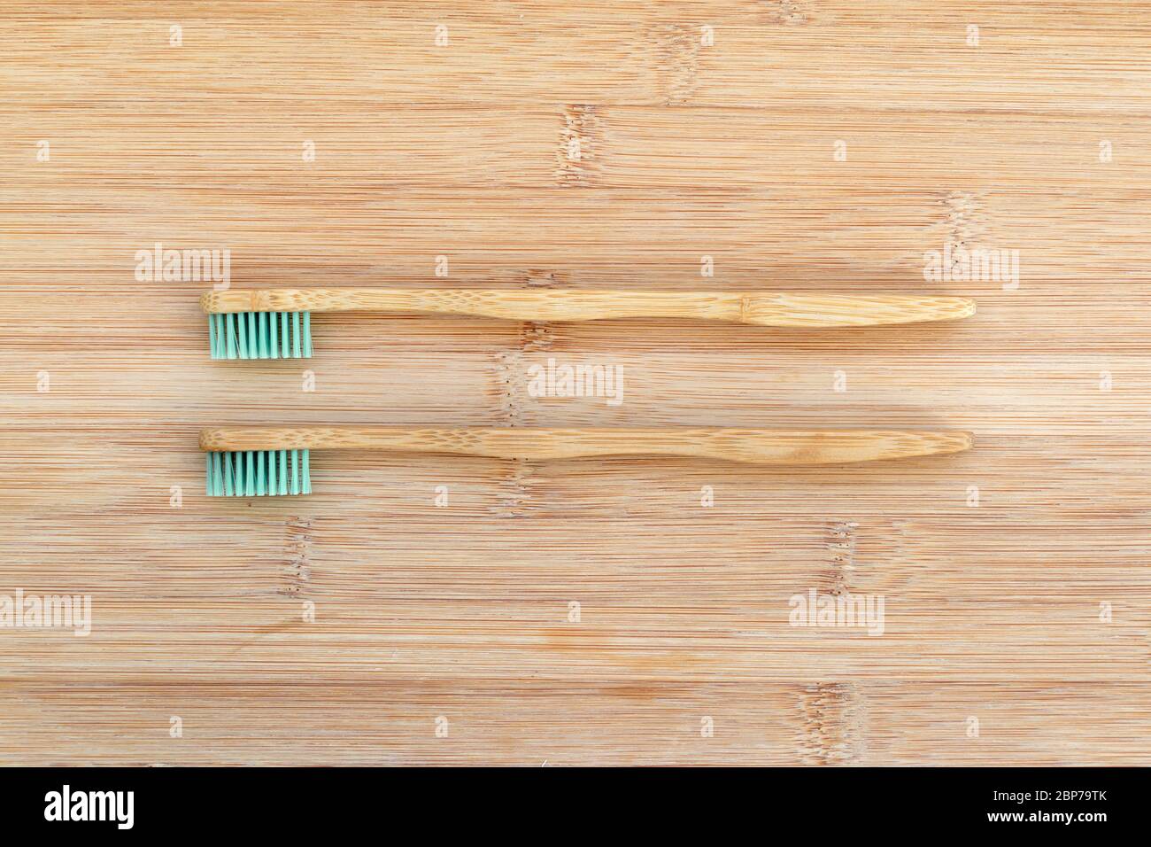 Ensemble de deux brosses à dents en bambou sur fond de bois. Zéro déchet, matériau biodégradable, concept d'environnement Banque D'Images