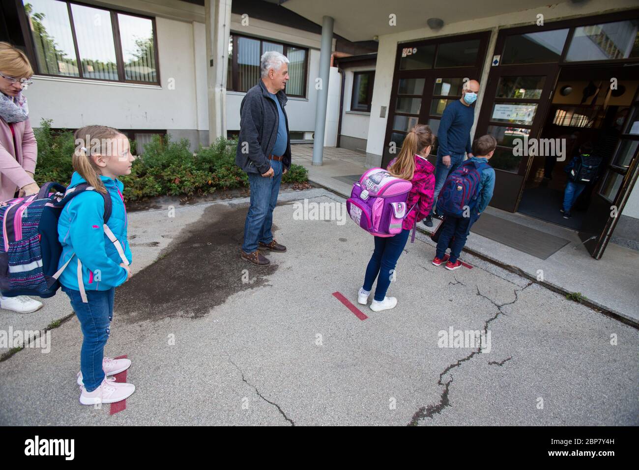 Les enfants attendent à des endroits désignés pour respecter la distance de sécurité avant d'entrer dans une école primaire.les élèves des trois premières années d'école primaire ainsi que les élèves de la dernière année d'école secondaire en Slovénie retournent dans les écoles après deux mois d'isolement dû à l'épidémie du coronavirus (Covid-19). Banque D'Images