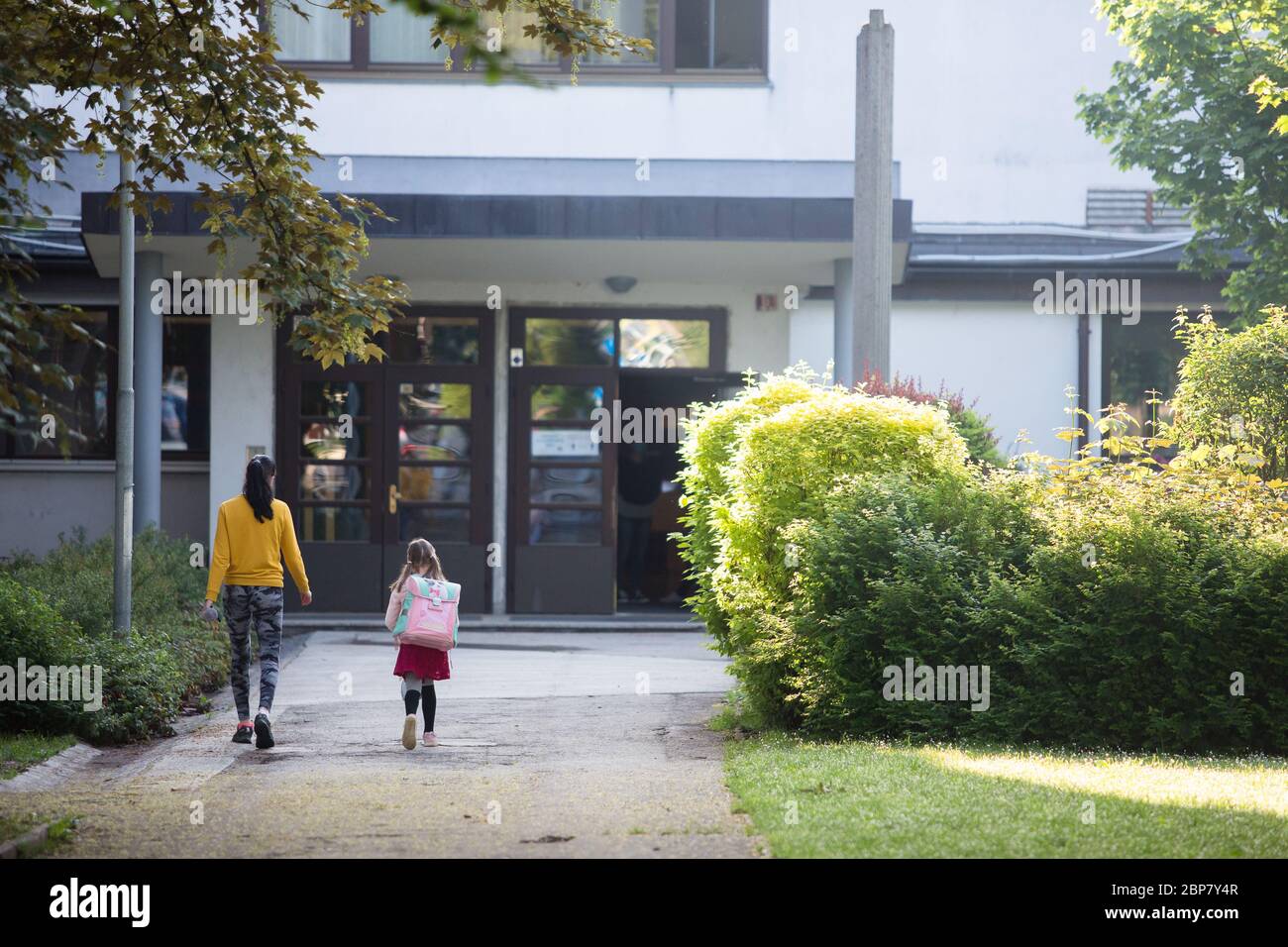 Un parent emmène un enfant dans une école primaire.les élèves des trois premières années de l'école primaire ainsi que les élèves de l'année dernière des écoles secondaires en Slovénie retournent dans les écoles après deux mois de confinement dû à l'épidémie du coronavirus (Covid-19). Banque D'Images