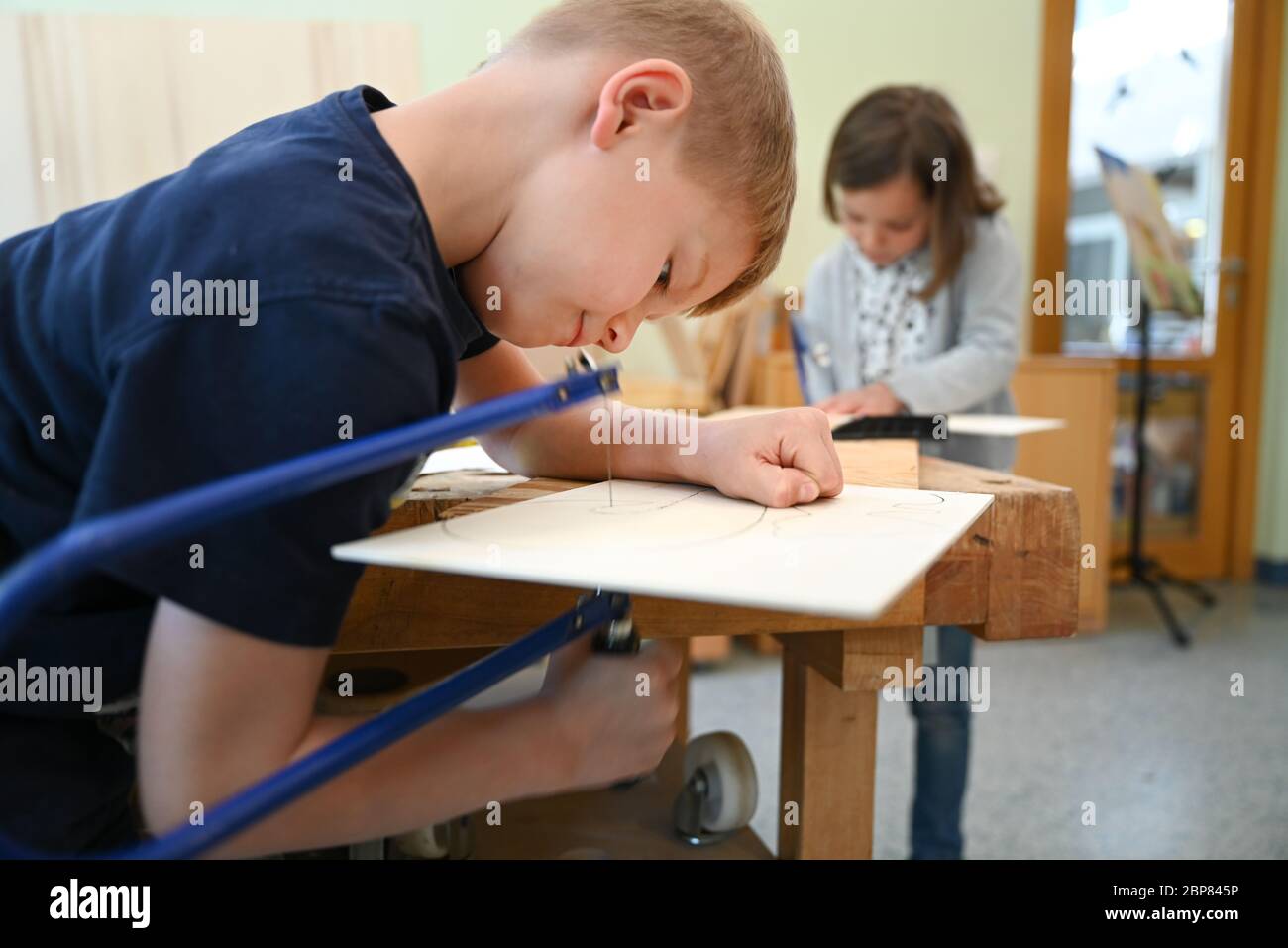 Friedrichshafen, Allemagne. 18 mai 2020. Deux enfants travaillent avec des scies à chantourner dans la maternelle Wiggenhausen. La maternelle municipale de toute la journée a jusqu'à présent offert des soins d'urgence. Credit: Felix Kästle/dpa/Alay Live News Banque D'Images