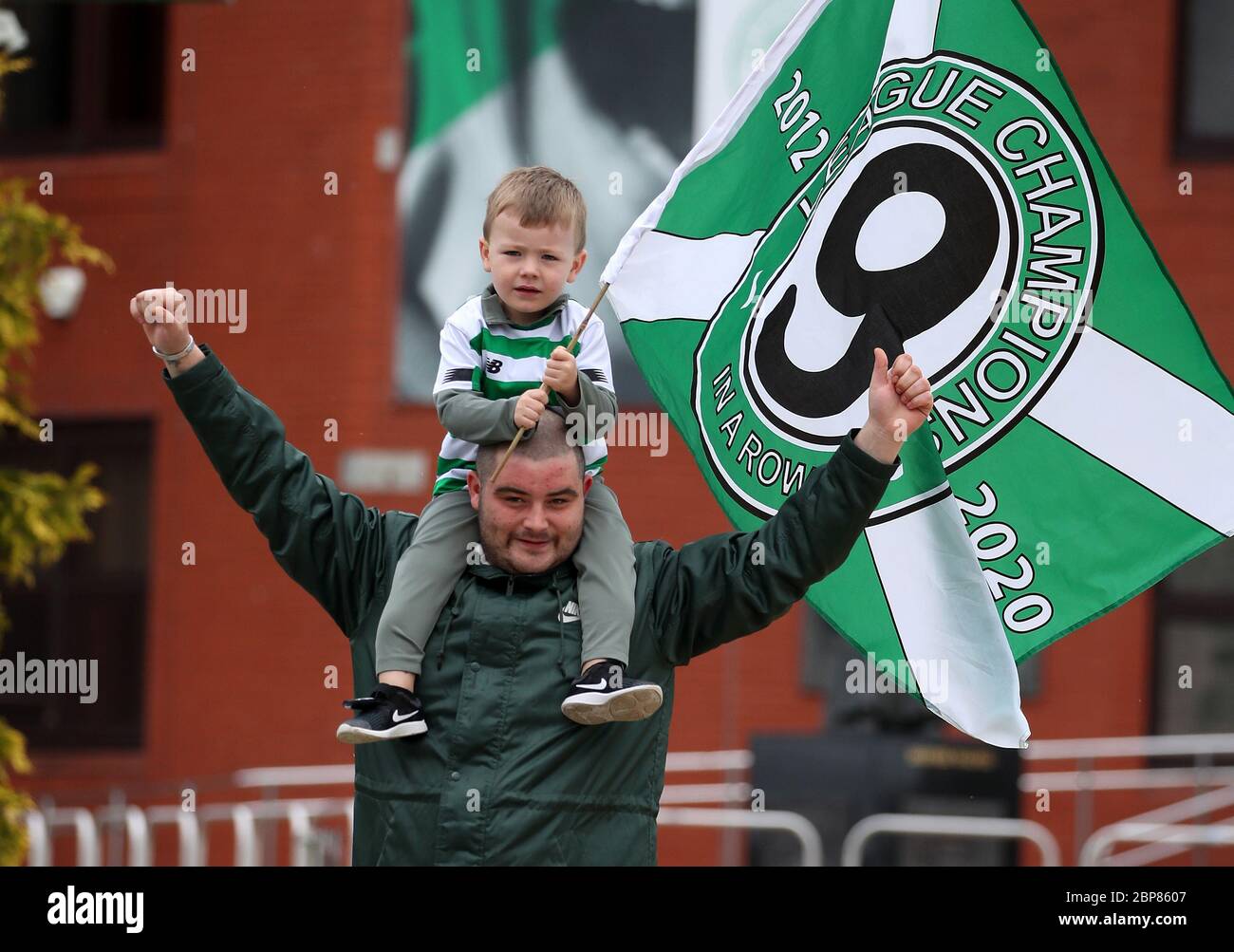 Deux fans celtiques arboront un drapeau des champions de la Ligue devant le Celtic Park, stade du Celtic FC. Banque D'Images