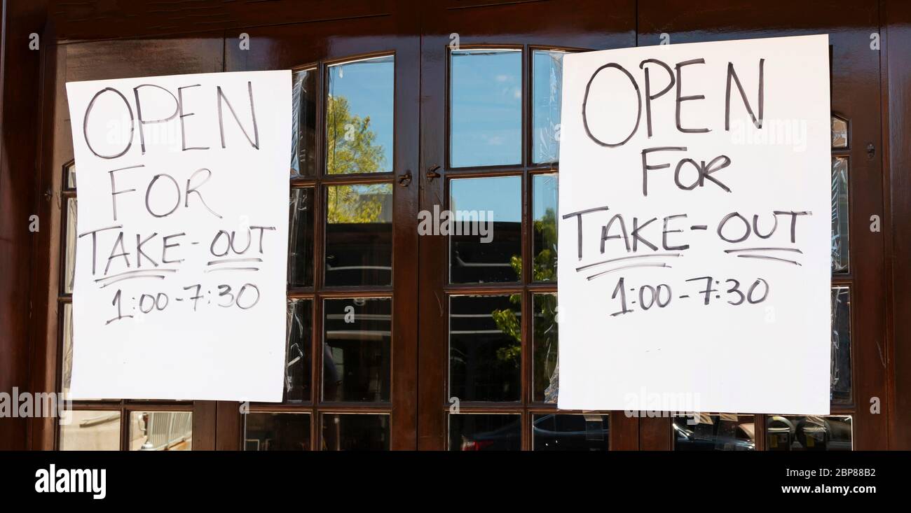 Un restaurant a deux affiches écrites à la main sur sa fenêtre pour informer la communauté qu'il est ouvert pour les plats à emporter uniquement en raison du coronavirus, C. Banque D'Images Un restaurant a deux affiches écrites à la main sur sa fenêtre pour informer la communauté qu'il est ouvert pour les plats à emporter uniquement en raison du coronavirus, C. Banque D'Images