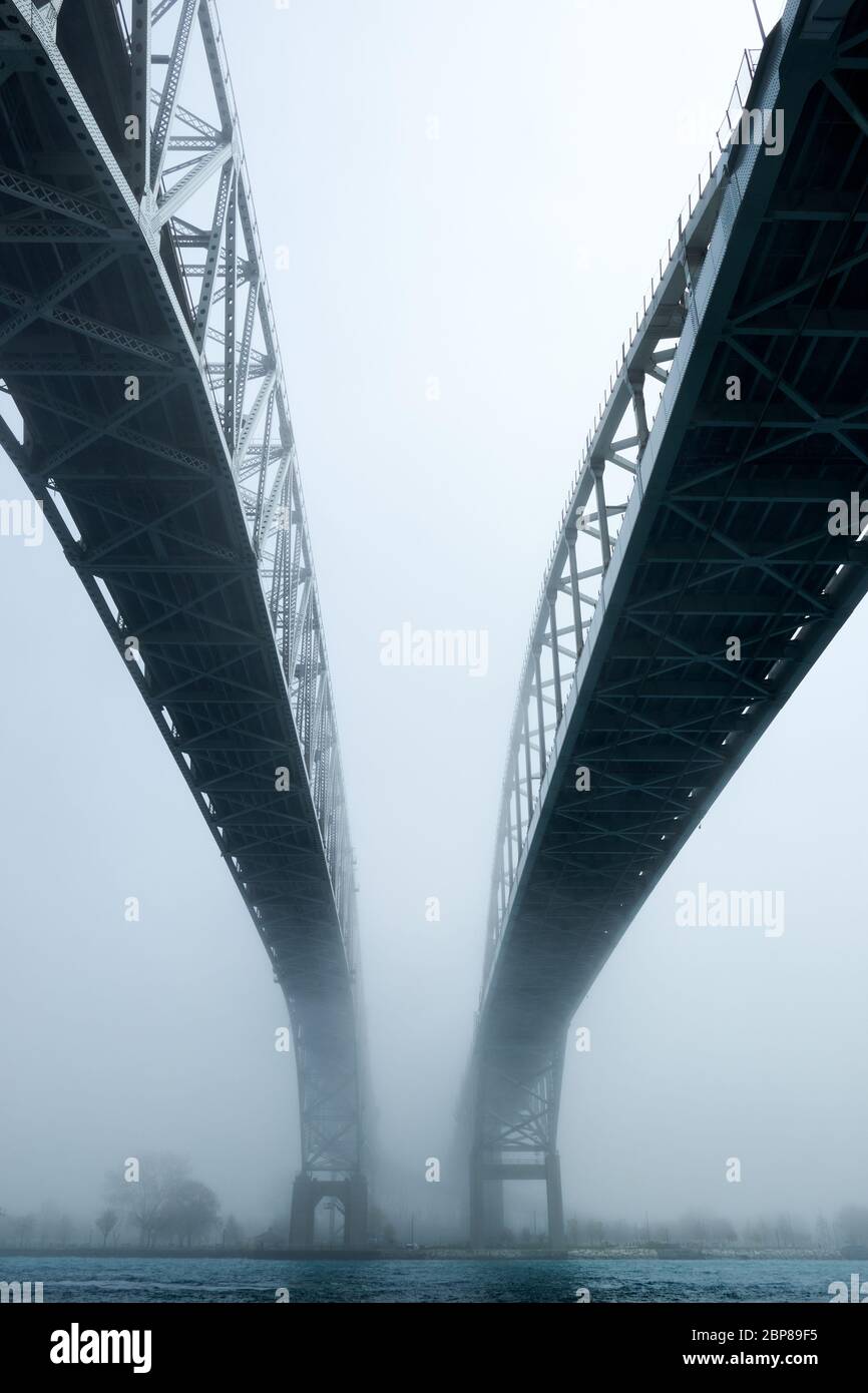 Brouillard entourant deux ponts sur la rivière. Chemin menant à l'avenir inconnu de sortir de la brume. Banque D'Images