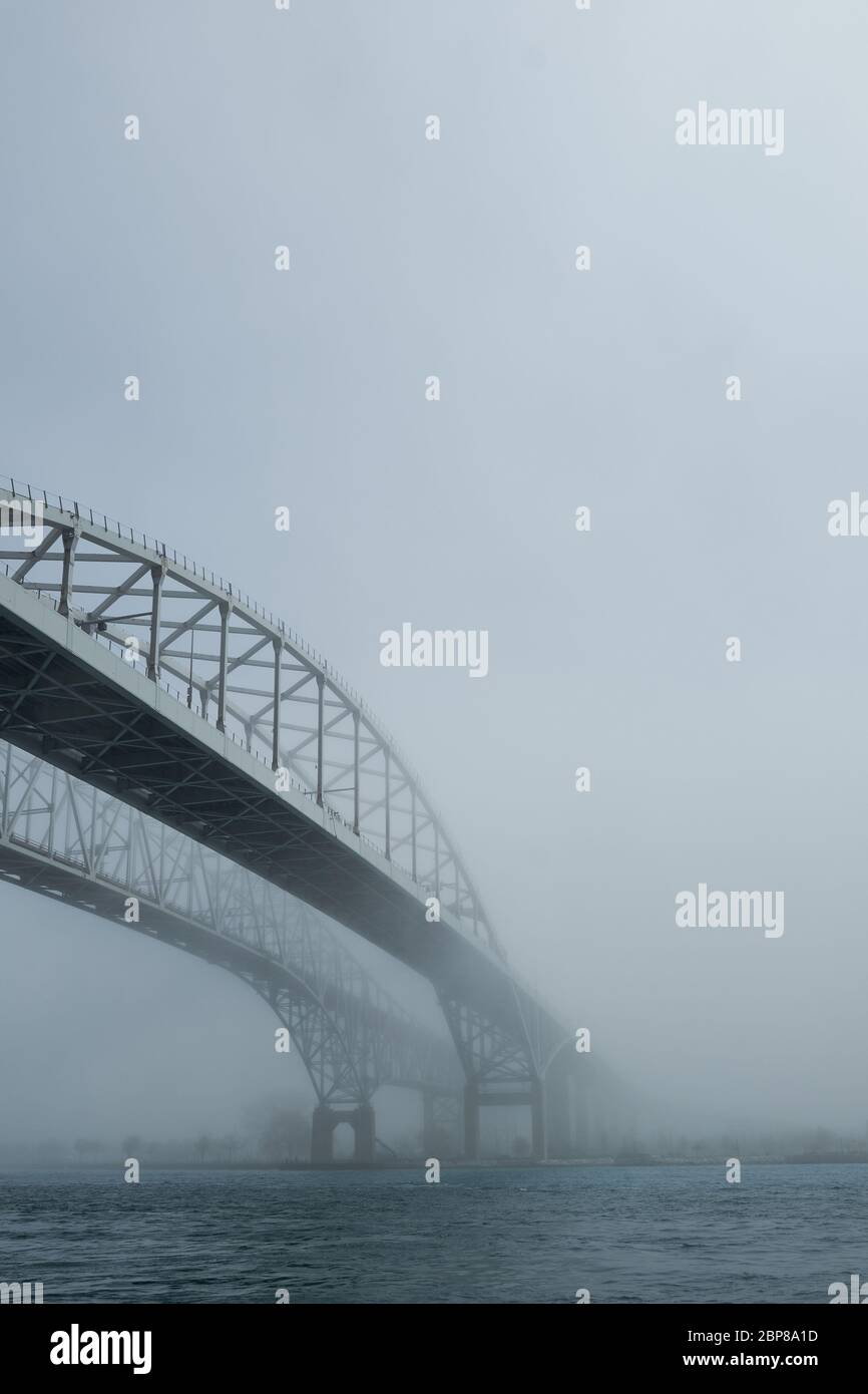 Brouillard entourant deux ponts sur la rivière. Chemin menant à l'avenir inconnu de sortir de la brume. Banque D'Images