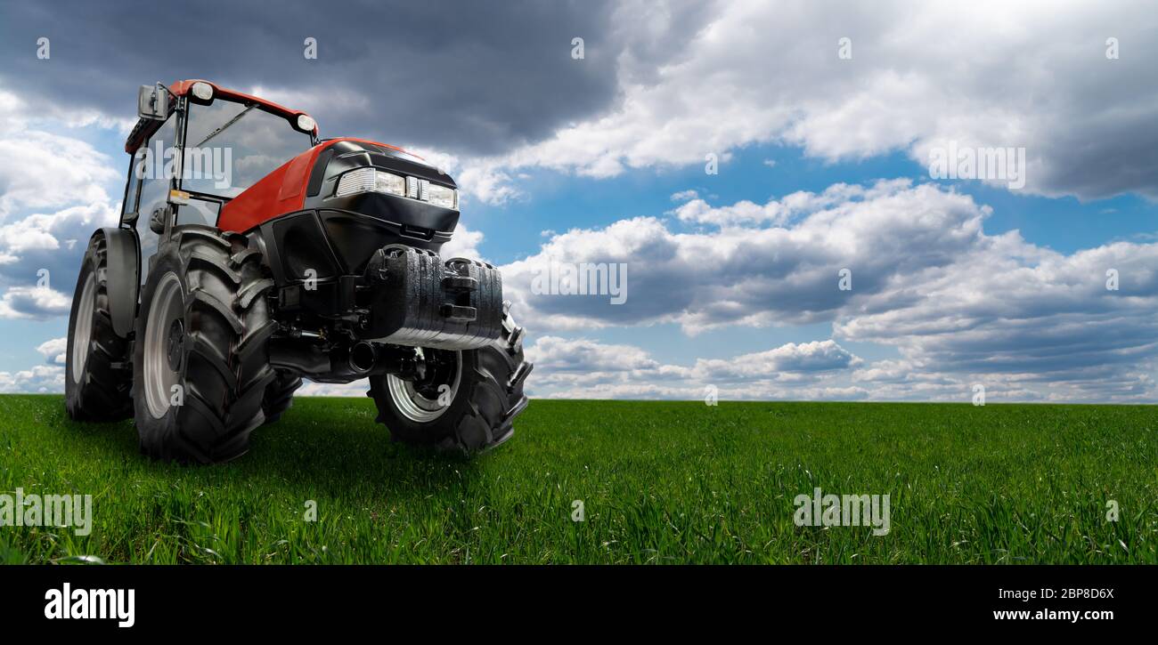 Tracteur rouge sur un champ agricole Banque D'Images