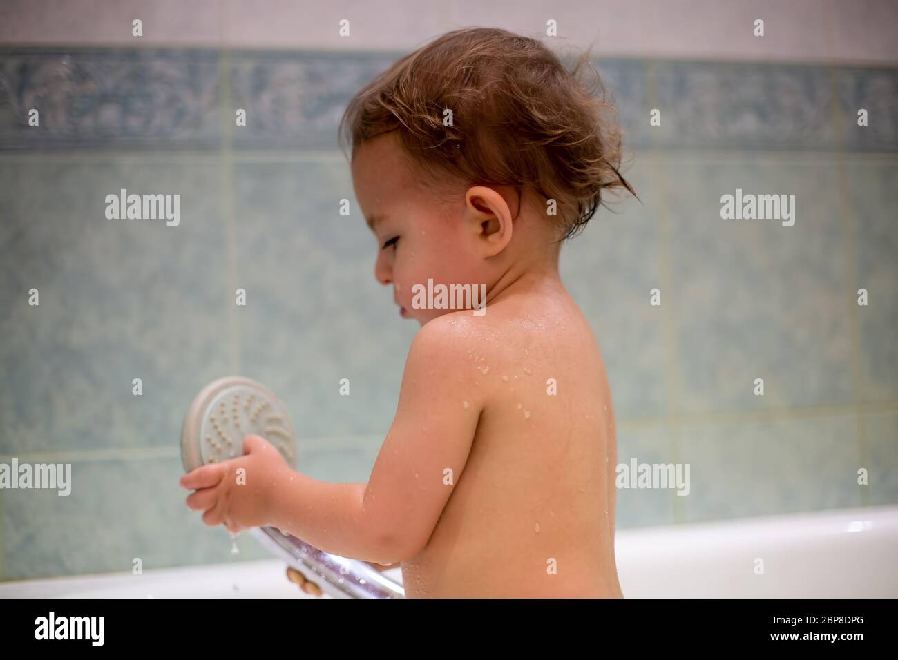 Un Petit Bebe Mignon Est Debout Dans Le Bain Pendant Le Bain Et Tient Un Arrosoir Dans Ses Mains L Ame Joue Avec Elle Sur Le Fond D Un Photo Stock Alamy