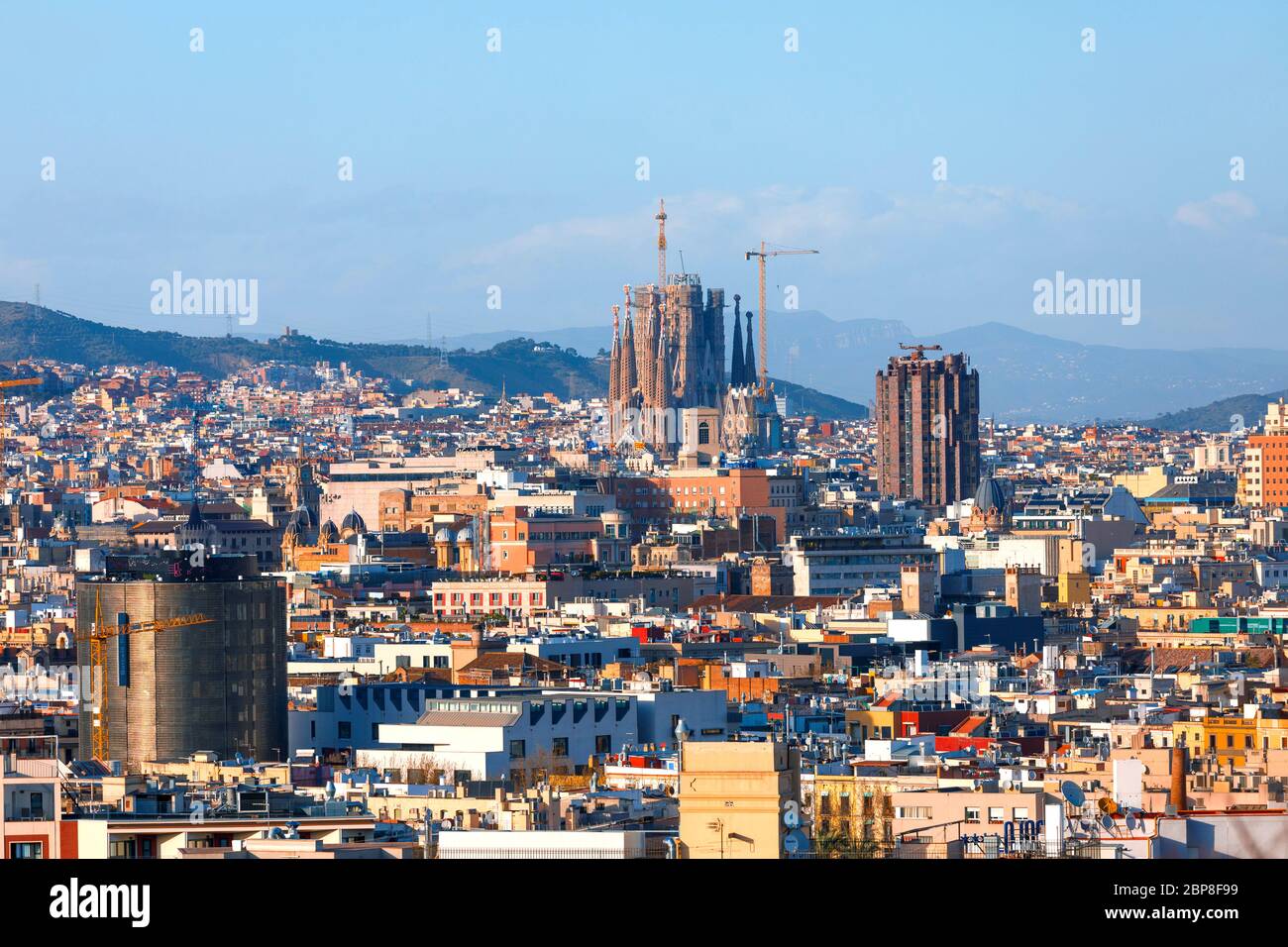 Barcelone paysage urbain l'après-midi, maisons colorées et ensoleillées et montagnes en arrière-plan Banque D'Images