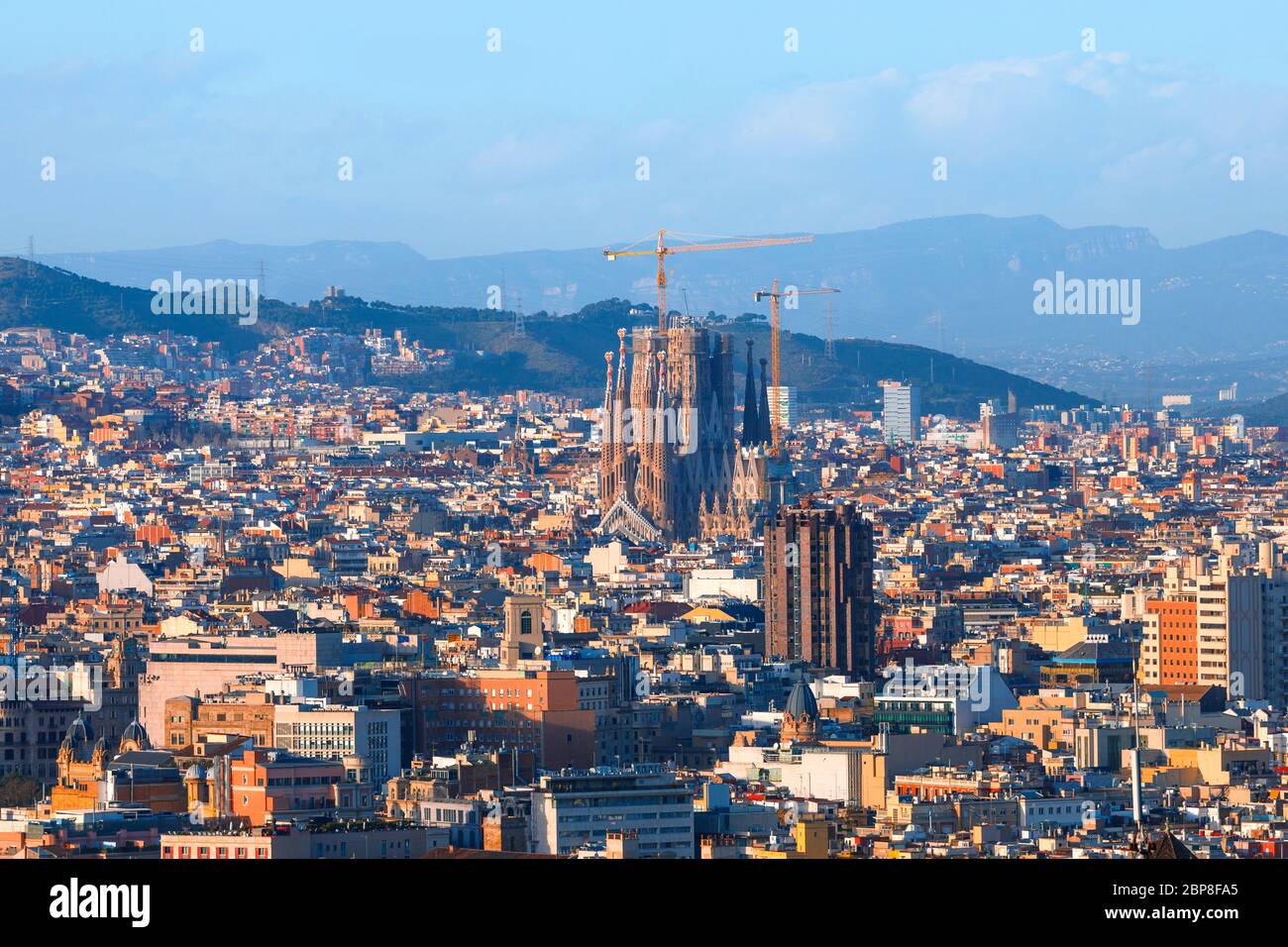 Barcelone citiscape l'après-midi, maisons colorées et ensoleillées et montagnes en arrière-plan Banque D'Images