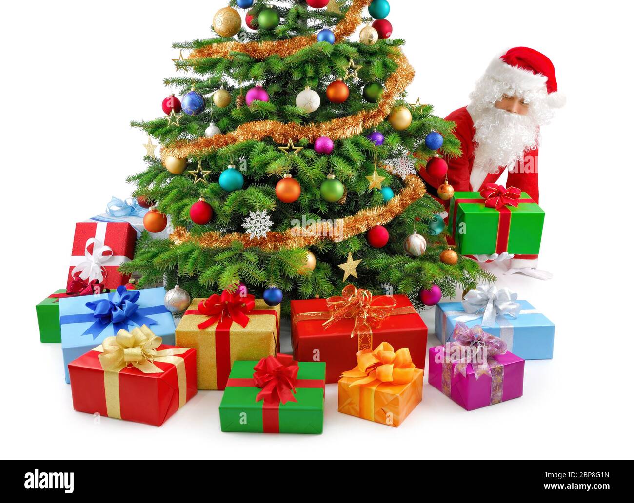 Weihnachtsmann kniet und neben Weihnachtsbaum high die Geschenke hin Banque D'Images