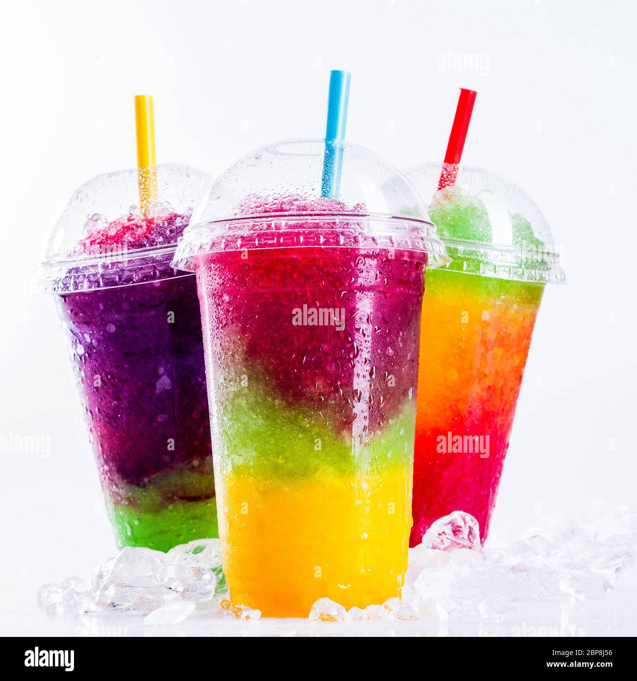 STILL Life gros plan de Rainbow coloré Layered fruits glacés boissons de la neige en glace sur la surface blanche couverte en plastique à emporter avec Drinkin Banque D'Images