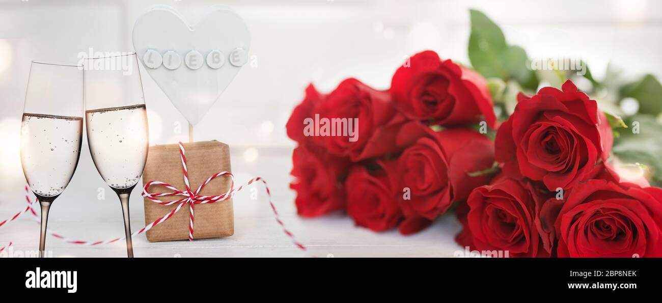 Roses rouges avec champagne et un cœur décrit avec amour sur un fond blanc d'offres de saint Valentin ou un mariage Banque D'Images