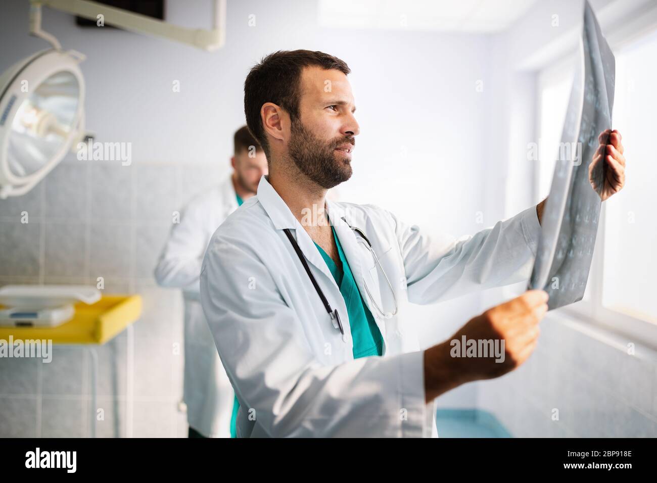 Portrait d'un jeune médecin vérifiant les rayons X à l'hôpital pour établir un diagnostic Banque D'Images