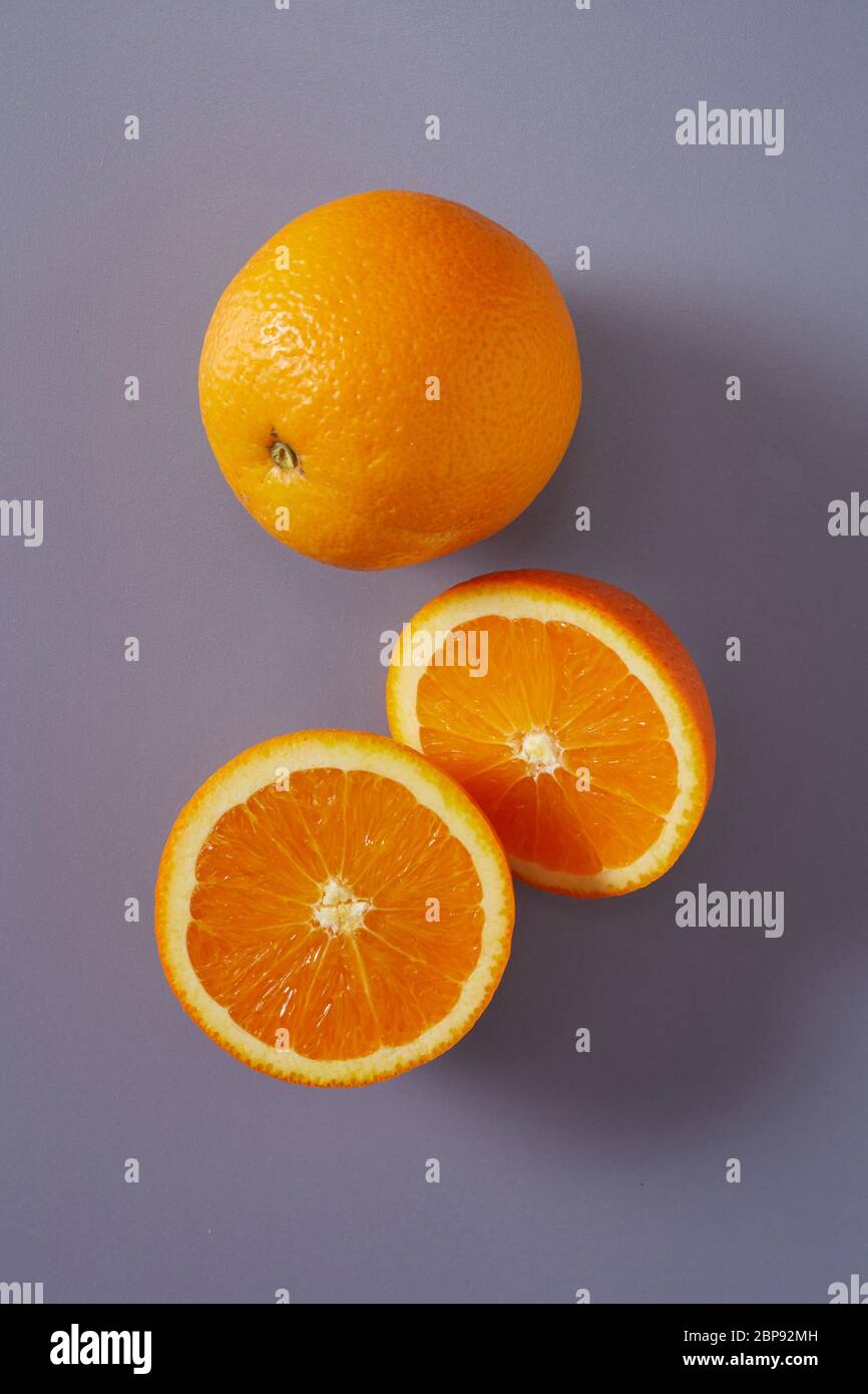 Mandarine, orange douce ensemble et coupées en deux pour montrer la pulpe juteuse et segments sur un fond gris dans un régime sain et produire concept Banque D'Images