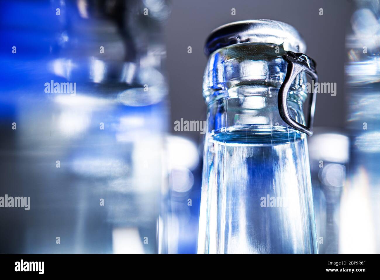 Gros plan des bouteilles d'eau minérale en verre transparent avec balais à franges. Banque D'Images