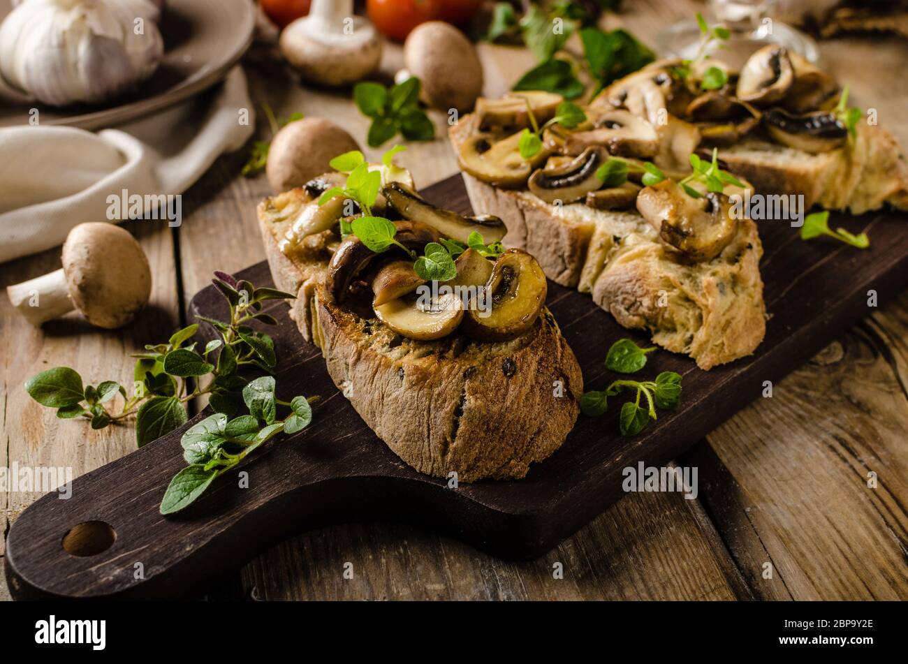 Griller le pain rustique avec de l'ail, les champignons et les herbes, de style rustique photo Banque D'Images