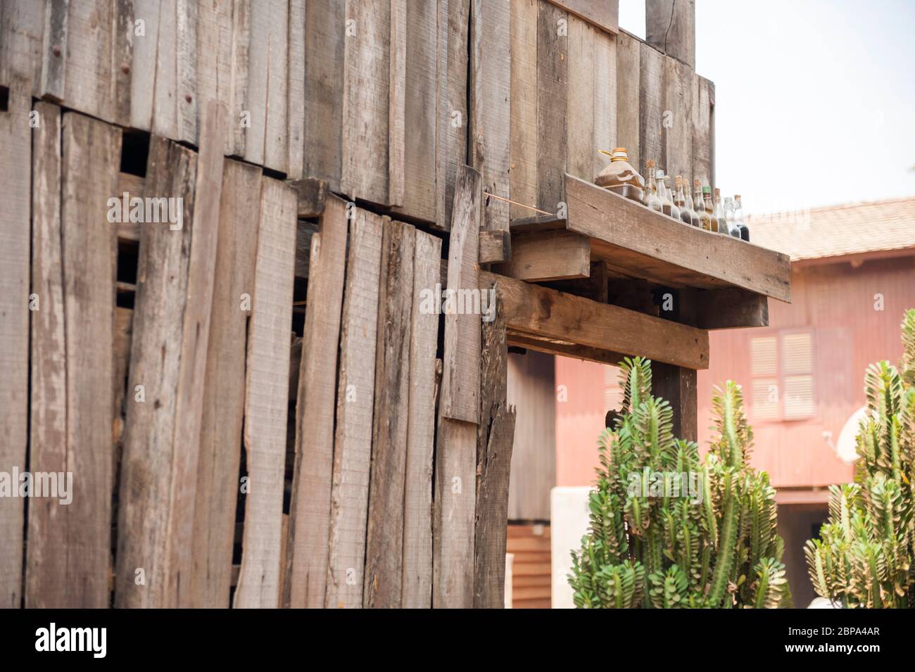Bouteilles alignées sur le côté d'une maison dans un village rural de Cham. Cambodge central, Asie du Sud-est Banque D'Images