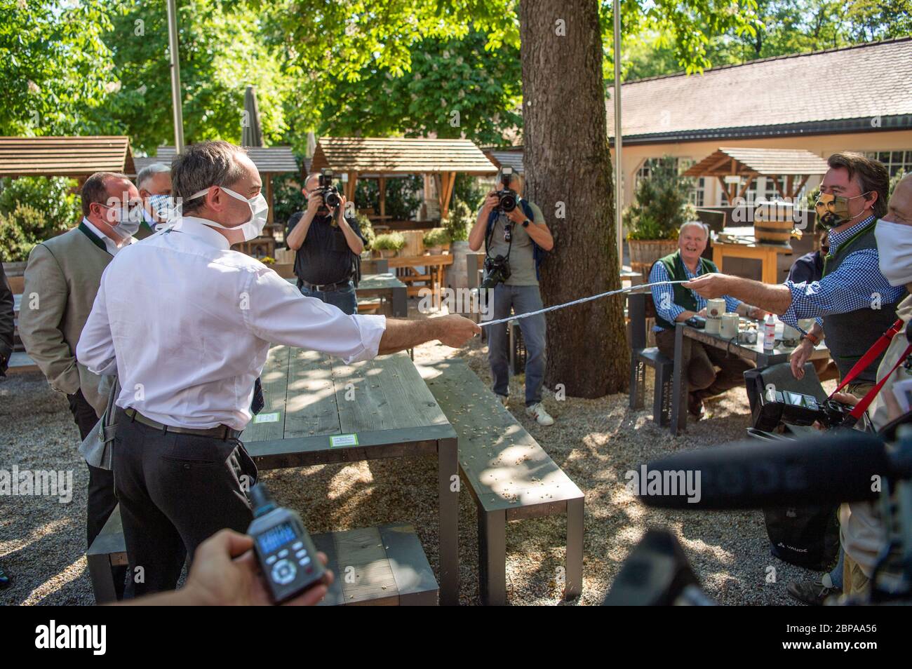 Munich, Allemagne. 18 mai 2020. Hubert Aiwanger (vote libre, 3e de gauche), ministre des Affaires économiques de Bavière, se présente avec un mètre par le visiteur de bière Harald Kaiser lors de sa visite. Aiwanger a visité un café en plein air à Munich au début de la gastronomie en plein air et a étudié le concept d'hygiène. Crédit : Lino Mirgeler/dpa/Alay Live News Banque D'Images