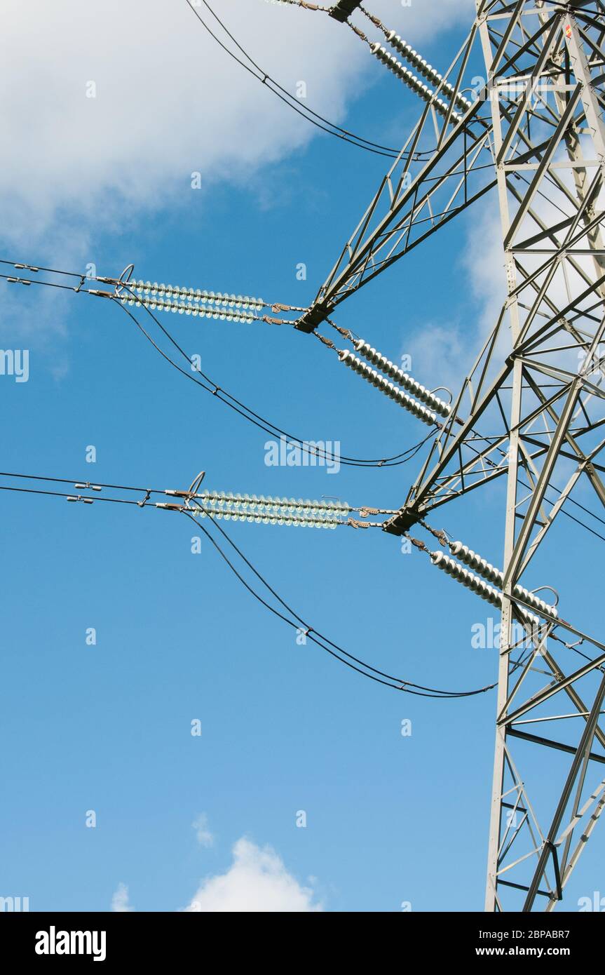 Autour du Royaume-Uni - électricité Pylons contre un ciel bleu avec des nuages blancs moelleux Banque D'Images