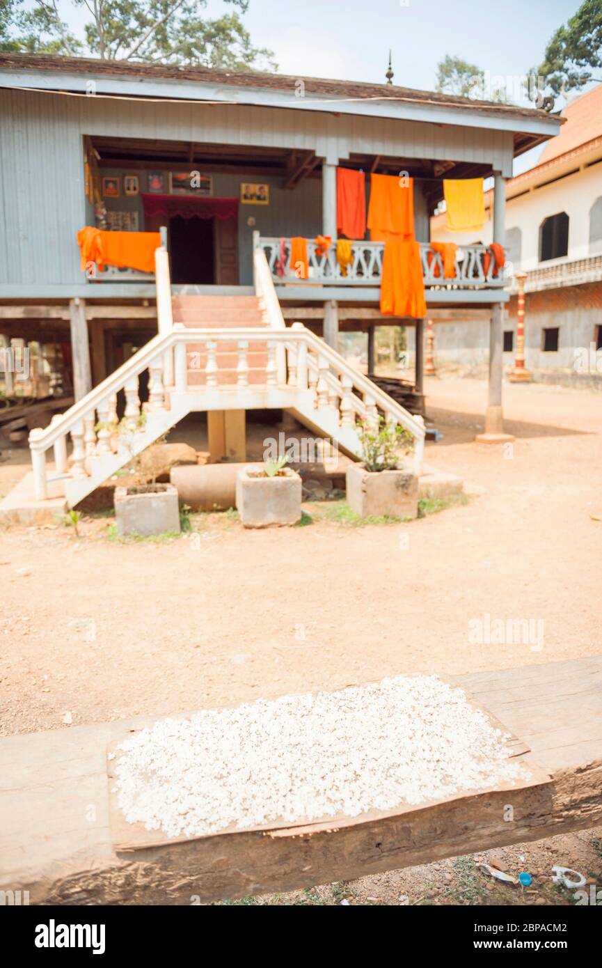 Séchage de riz et peignoirs de Monk suspendus à l'extérieur d'un bâtiment, province de Kampong Cham, Cambodge, Asie du Sud-est Banque D'Images
