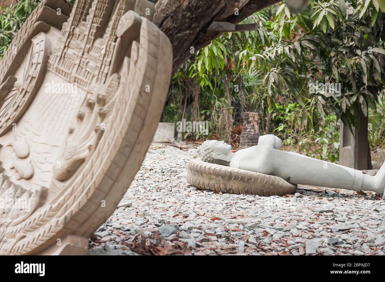 Statue de Bouddha reposant sur un pneu dans le village de l'usine de sculpture de Bouddha de Kakaoh. Province de Battambang, Cambodge Banque D'Images