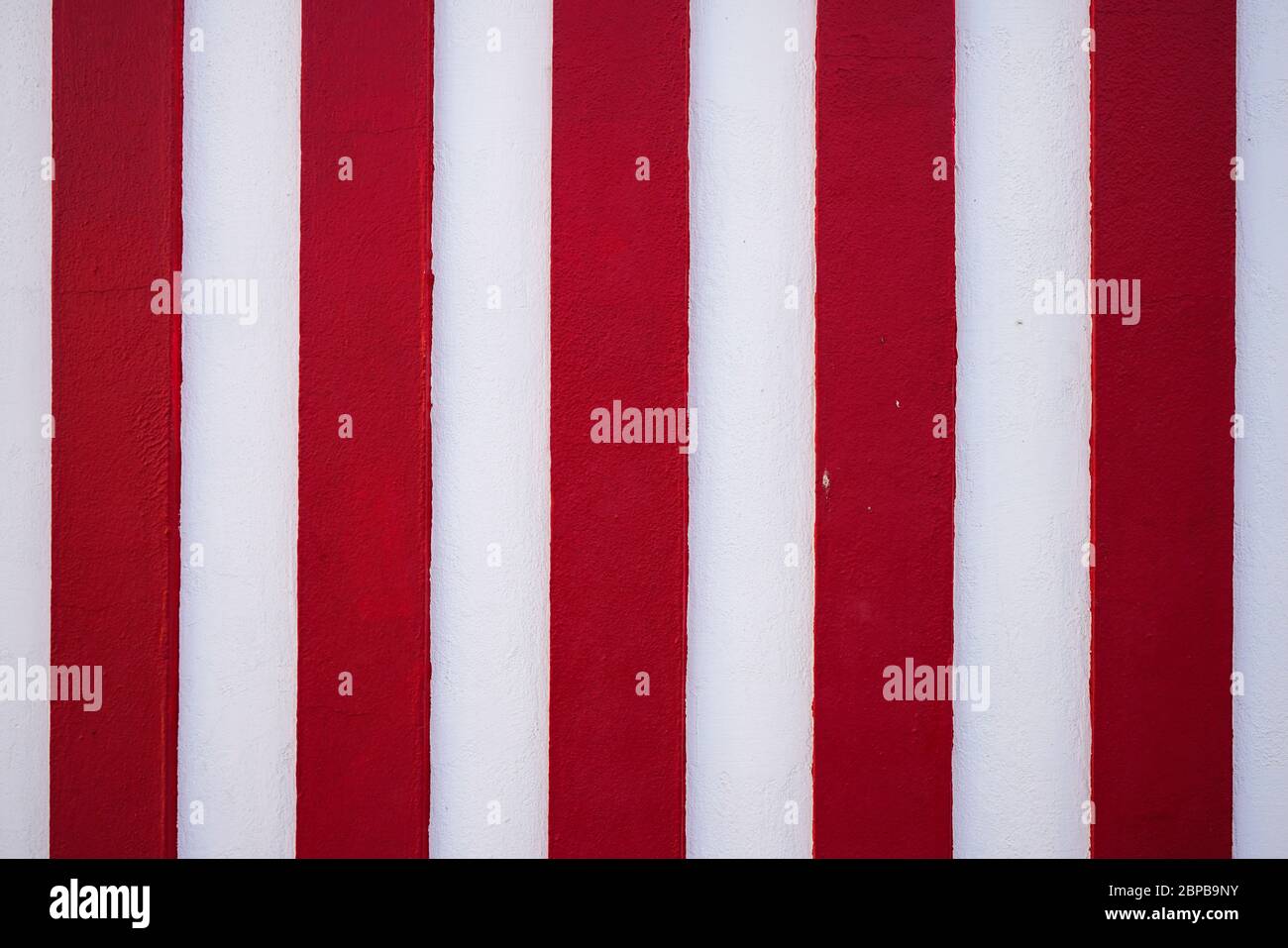 Motif d'arrière-plan à bandes verticales rouges et blanches. Une texture abstraite colorée à rayures ou un arrière-plan avec espace de copie. Banque D'Images