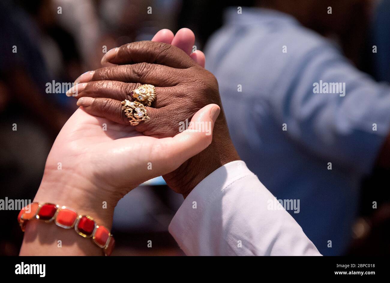 Les paroissiens de différentes races se joignent à la main pendant la messe à STS. Paroisse catholique de Teresa et Bridget à Saint-Louis Missouri, États-Unis. Banque D'Images