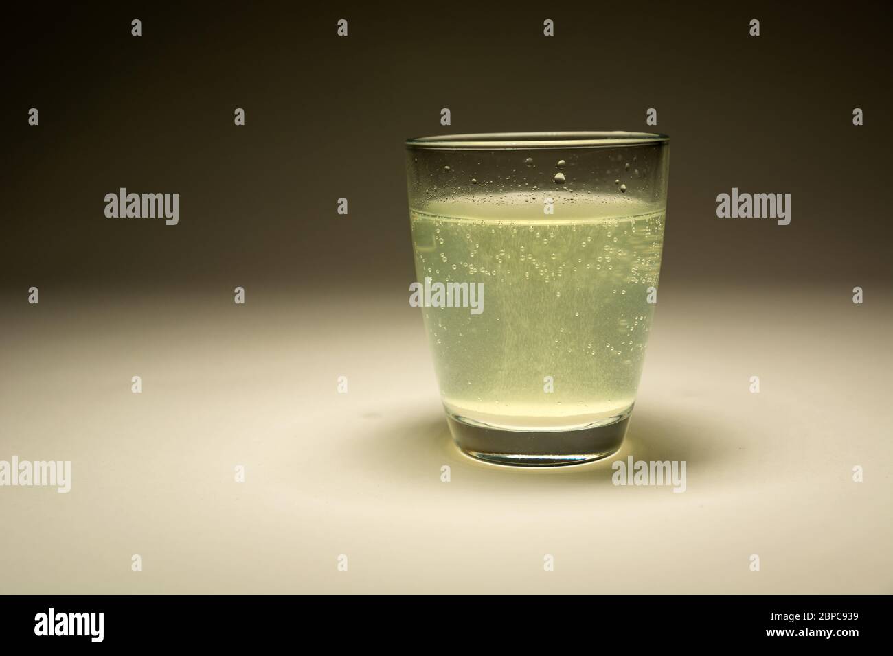 La tablette dissolvant dans l'eau dans un verre, vue droite Banque D'Images
