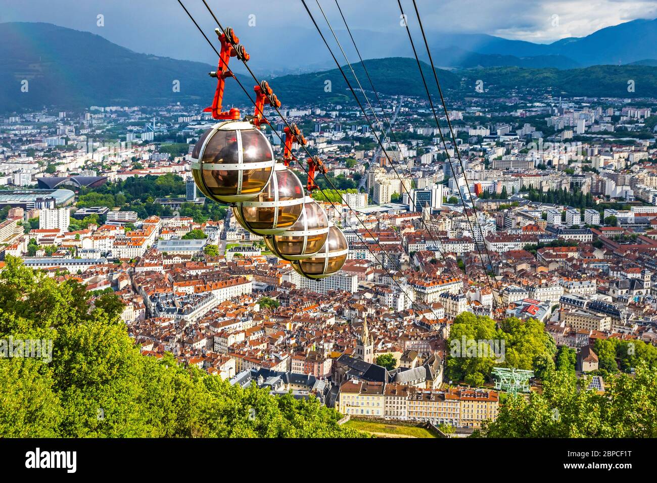 Vue aérienne pittoresque de Grenoble, région Auvergne-Rhône-Alpes, France. Téléphérique Grenoble-Bastille au premier plan. Alpes françaises à l'arrière Banque D'Images