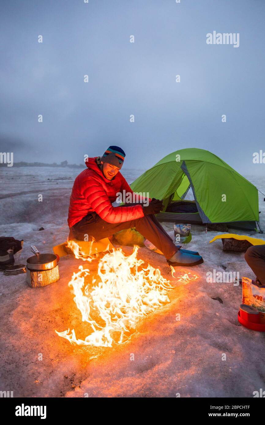 Mountaineer aime les feux de camp tout en campant sur un glacier, l'île de Baffin Banque D'Images