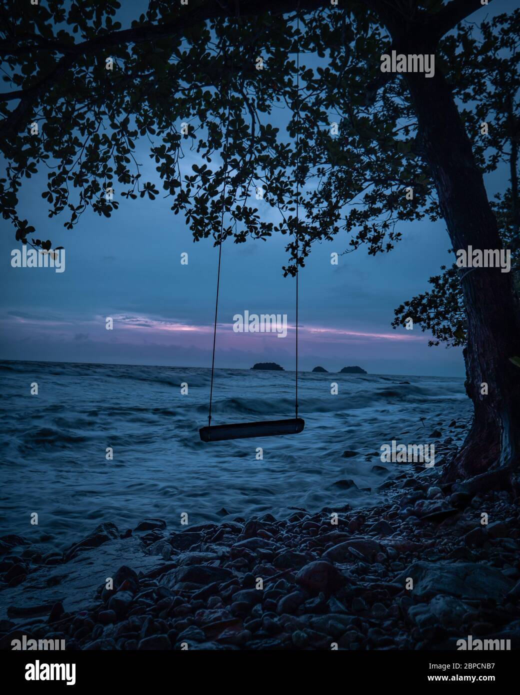 Une balançoire sur la plage la nuit Banque D'Images