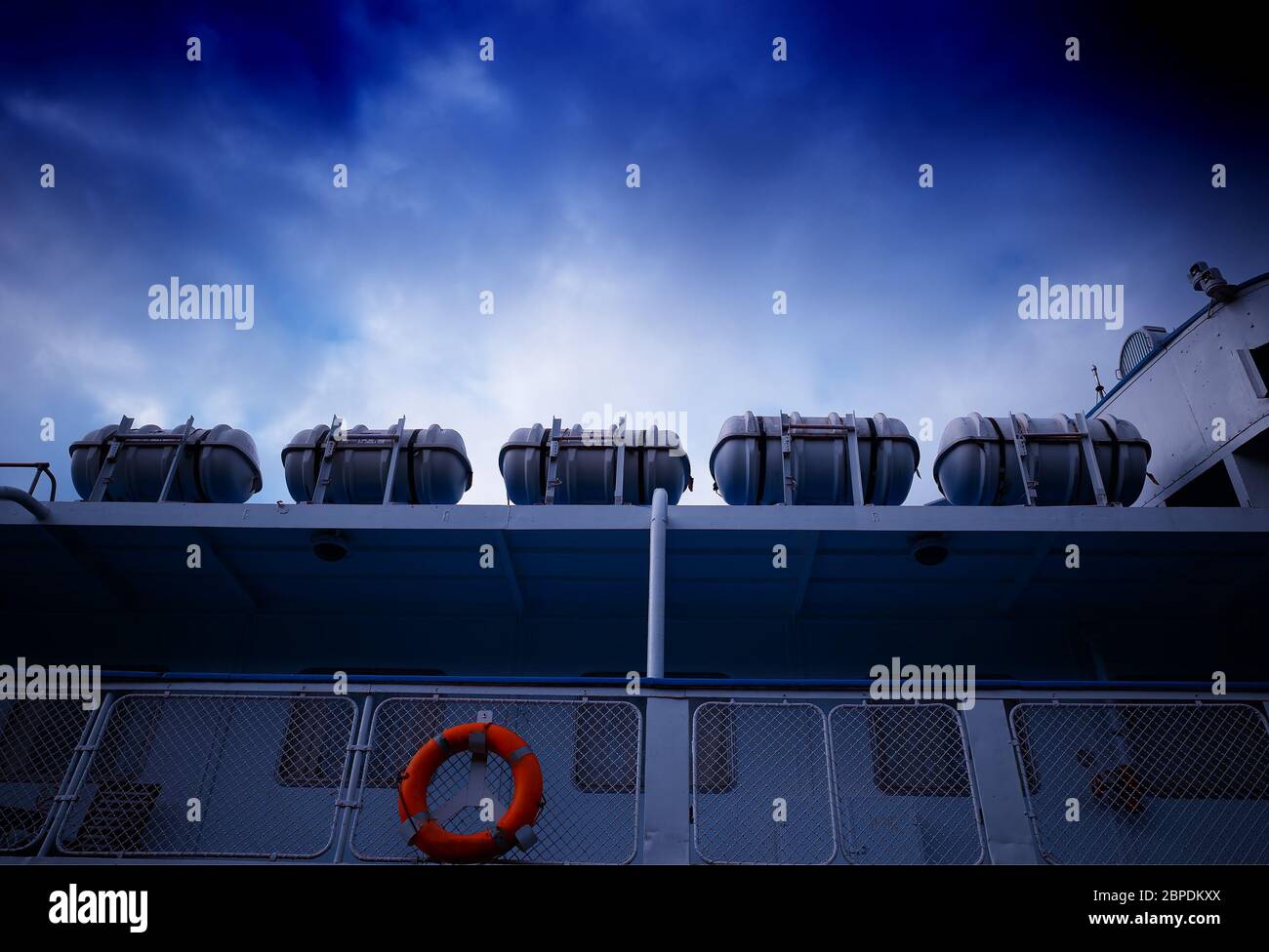 Cinq bateaux de sauvetage sur le bateau sous fond bleu foncé Banque D'Images