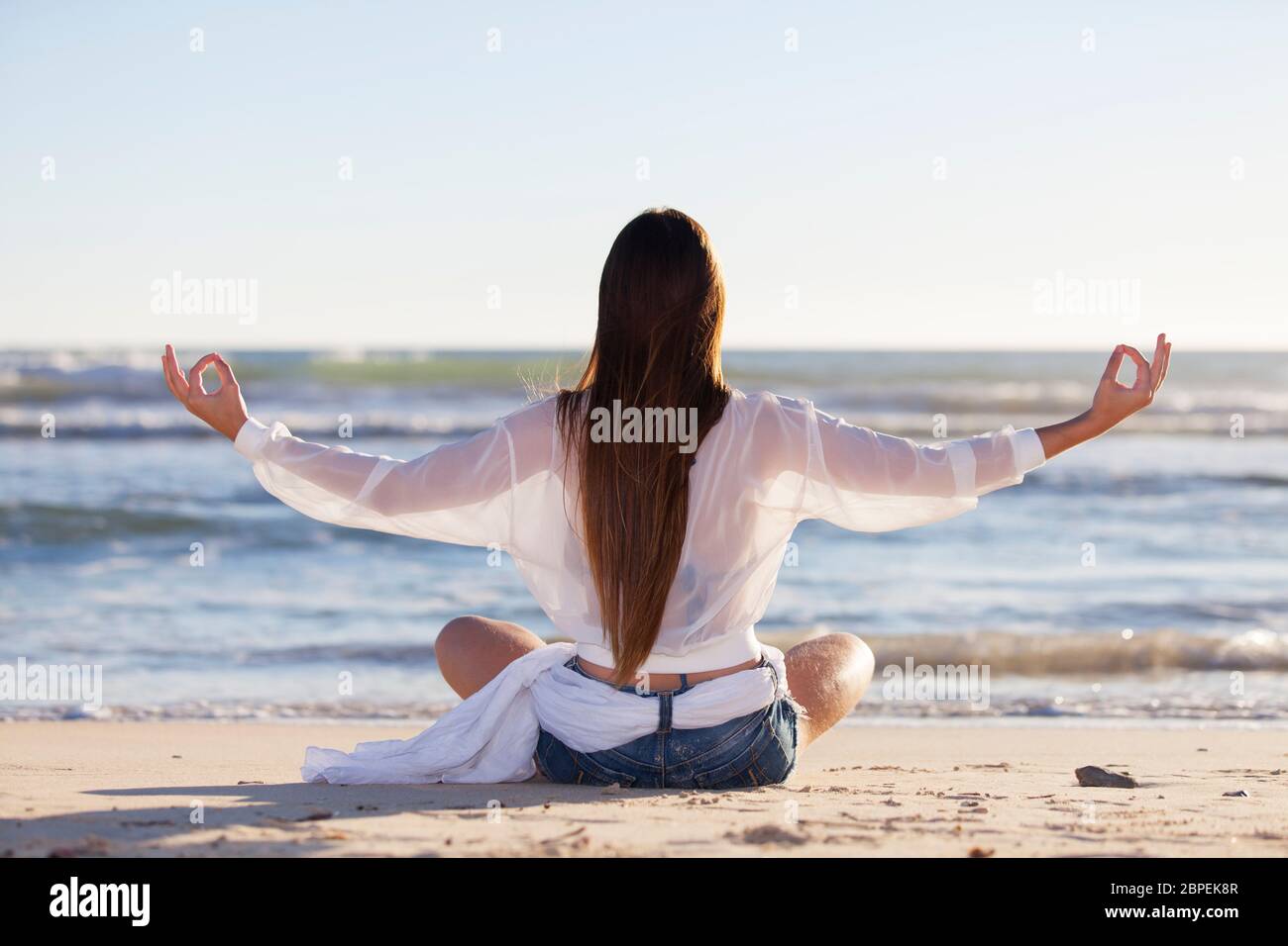 Junge Frau beim Yoga am Strand Banque D'Images