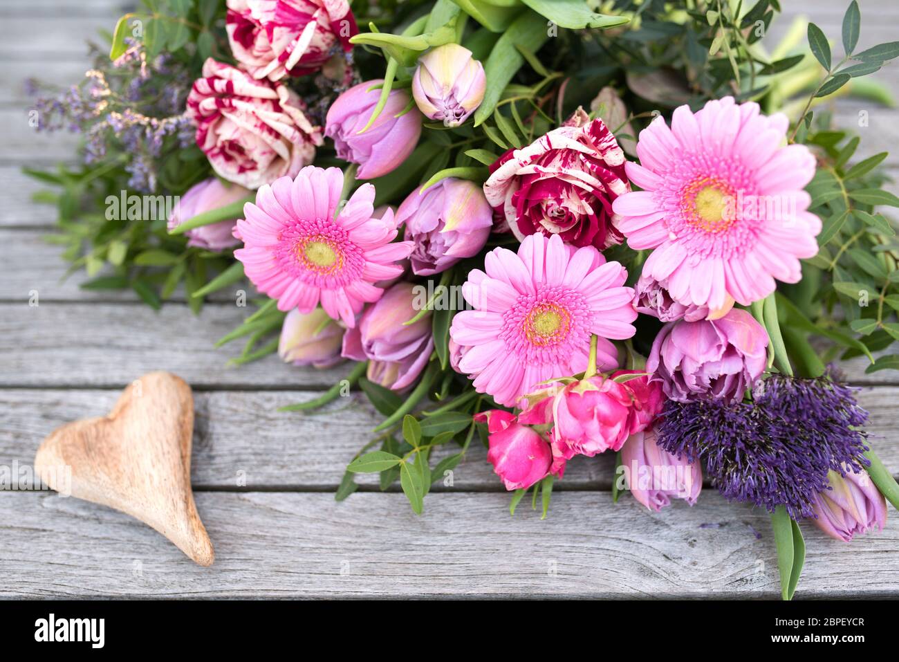 La vie toujours au printemps avec des fleurs et un coeur sur planches vintage gris pour la fête des mères Banque D'Images