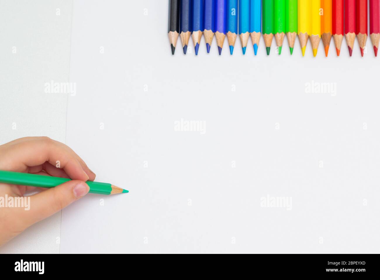 Vue De Dessus Du Dessin De La Main De Bebe Avec Un Crayon Vert Sur Papier Blanc Avec Le Jeu De Crayons De Couleur Concept De Peinture Pour Enfants Copier L Espace Pour