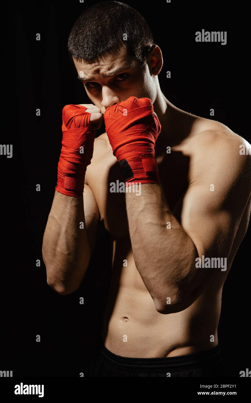 Boxer combattant masculin posant en position défensive confiante avec les  mains dans les flandages sur fond noir Photo Stock - Alamy