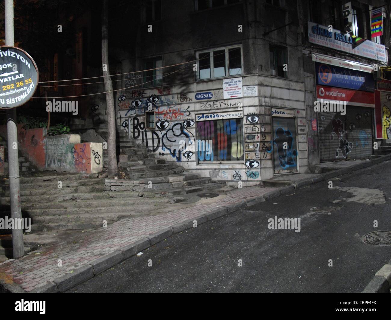 Vue nocturne d'une allée piétonne avec murs couverts de graffiti et grilles métalliques dans la zone de Galata à Istanbul, Turquie Banque D'Images