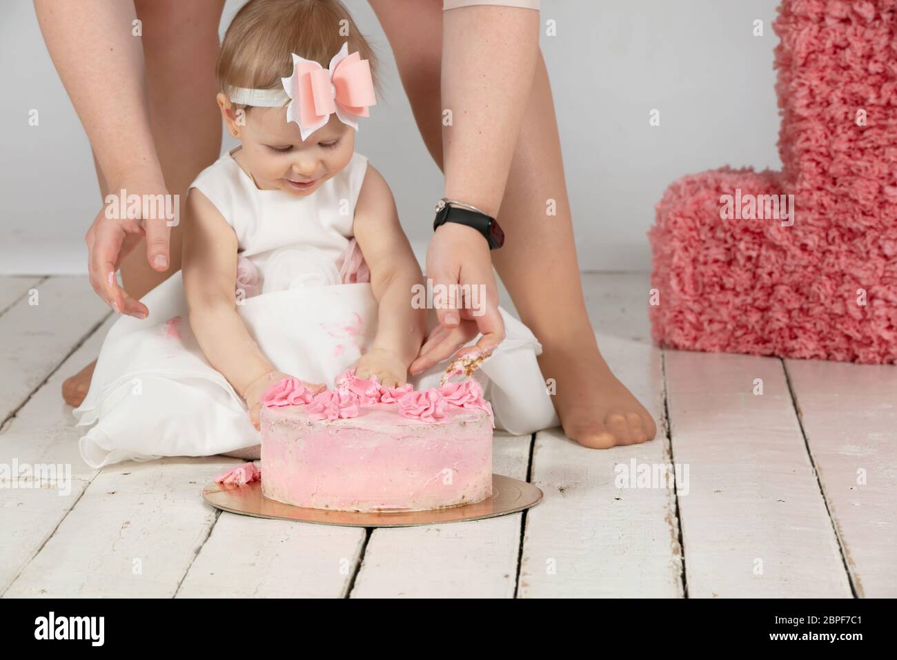 L Anniversaire De L Enfant Est D Un An Les Mains De Maman Et Un Bebe Magnifique Petite Fille Avec Un Gateau D Anniversaire Photo Stock Alamy