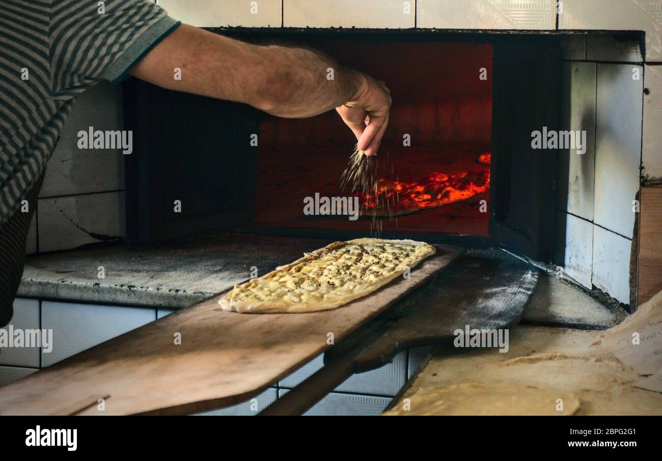 Boulanger turc musulman versant du sésame sur le traditionnel pain du ramadan, Saint mois des musulmans Banque D'Images